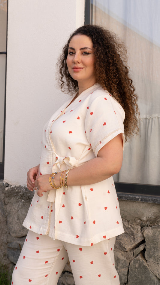 Kısa kollu kruvaze yaka, kırmızı kalp desenli pamuklu pijama takımı, uzun pijama altıyla.