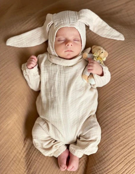 Krem renkli, pamuklu müslin kumaştan yapılmış çıtçıtlı bebek tulumu ve tavşan kulaklı şapka seti