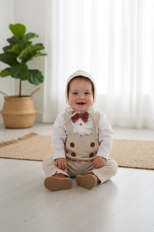 Erkek bebek keten salopet takımı, düğmeli gömlek ve şapka ile şık bir görünüm sunar.
