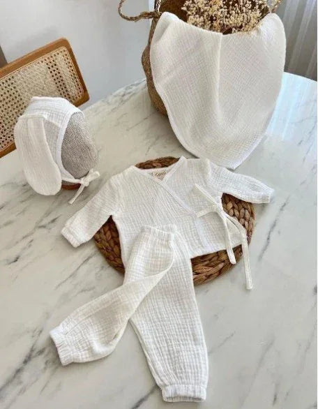 Beyaz, 4 parçalı erkek bebek takımı, kruvaze yaka body ve tavşan kulaklı şapka içerir.