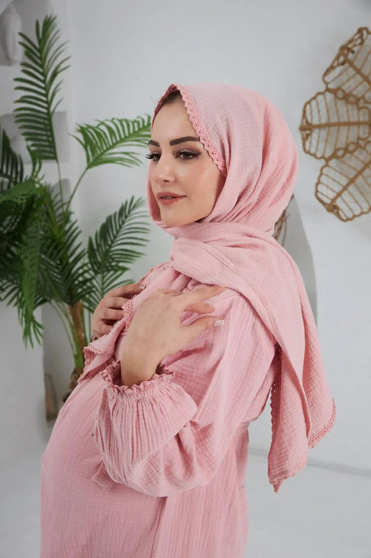 Pudra rengi, yumuşak dokulu bir şal, kenarları hafifçe fransız dantel detaylı.