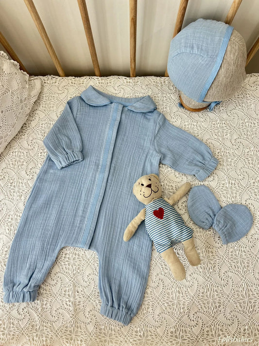 Beyaz, önden çıtçıtlı pamuklu erkek bebek tulumu, şapka ve eldiven seti.