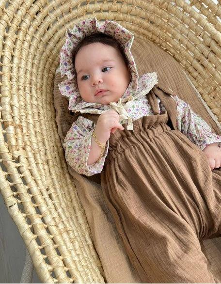 Çiçek desenli uzun kollu üst, salopet ve şapkalı kız bebek giyim seti.