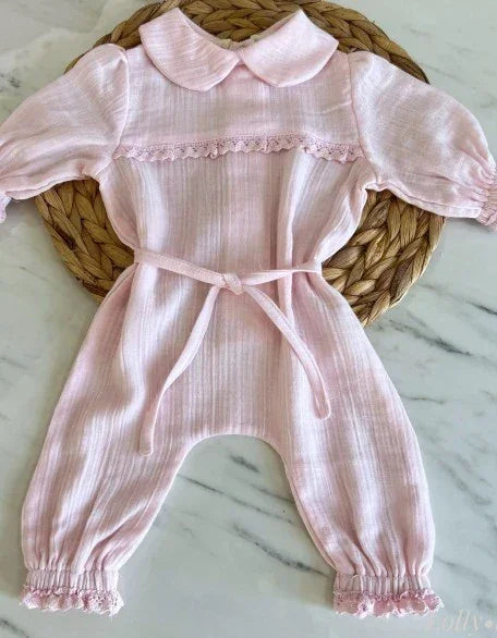 Beyaz organik pamuk müslin bebek tulumu, arkadan çıtçıtlı ve yumuşak dokulu.