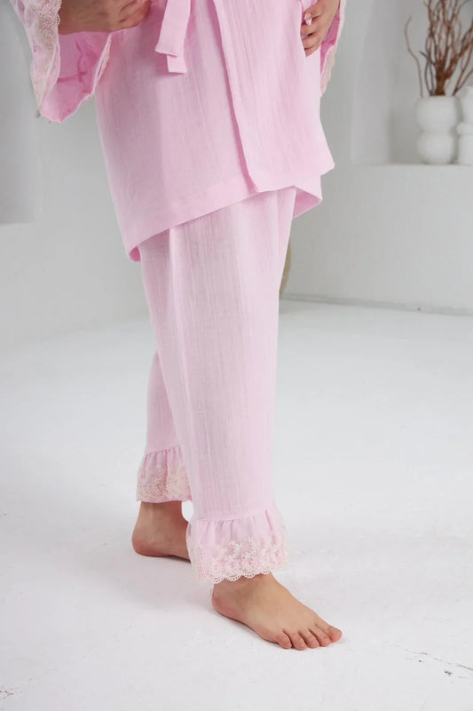 Pembe, dantel detaylı, uzun kollu kruvaze yaka pijama takımı ve rahat kesim alt.
