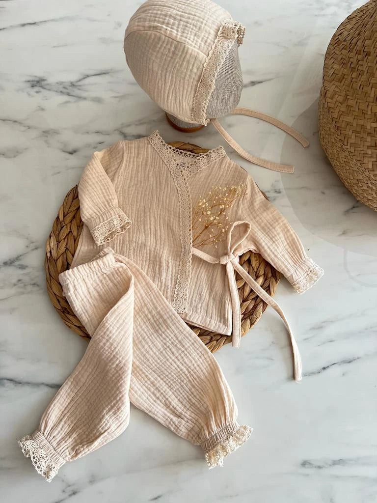 Üç parçadan oluşan vintage tarzı yenidoğan bebek alt üst takımı, pamuk müslin kumaştan.