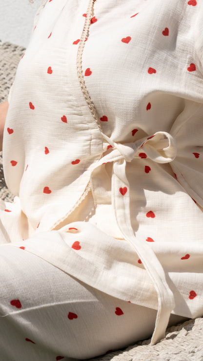 Kırmızı kalp desenli kısa kollu kruvaze pijama takımı, yumuşak pamuk kumaştan yapılmıştır.