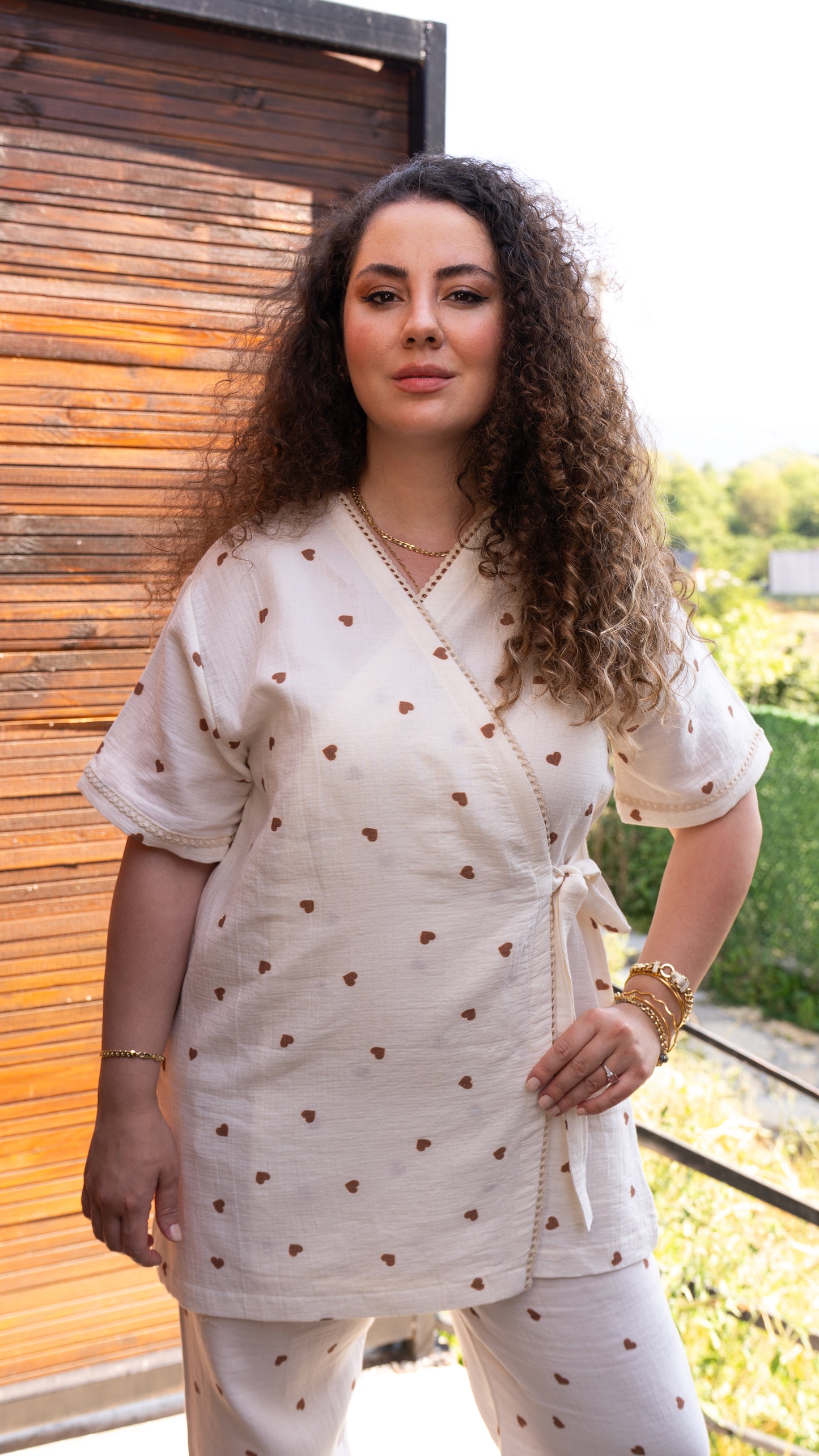 Kahverengi kalp desenli, kısa kollu kruvaze pijama takımı ve esnek bel lastikli pantolon.