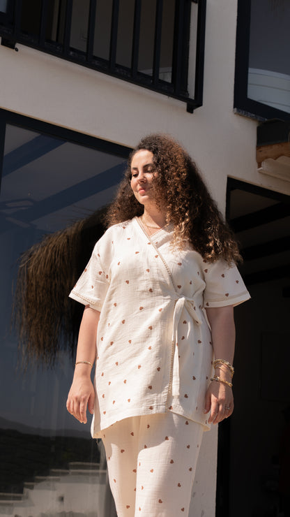 Kahverengi kalp desenli, kısa kollu kruvaze yaka pijama takımı ve esnek bel lastikli alt.