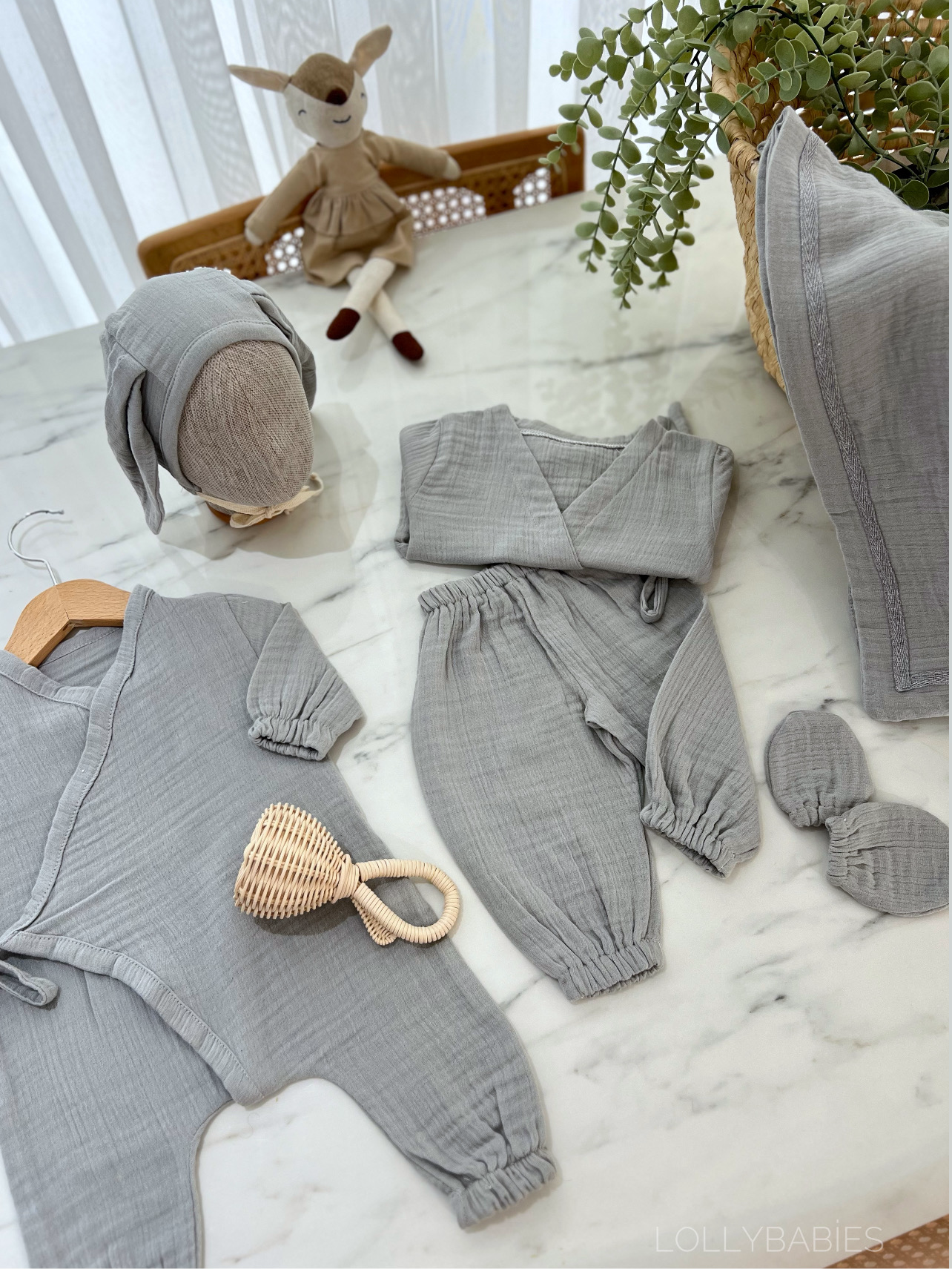 Gri renkli, 6'lı erkek bebek giyim seti, kruvaze yaka body ve tavşan kulaklı şapka içerir.
