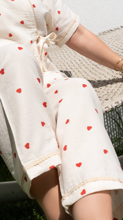 Kısa kollu, kırmızı kalp desenli kruvaze pijama takımı, yumuşak pamuk kumaştan yapılmıştır.