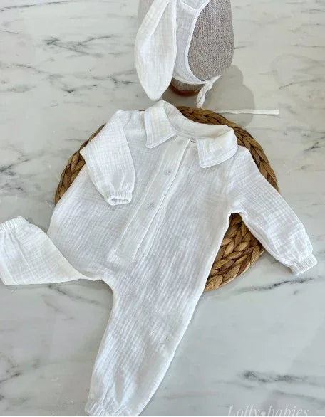 Beyaz, önden çıtçıtlı erkek bebek tulumu ve tavşan kulaklı şapka seti, %100 pamuk müslin.